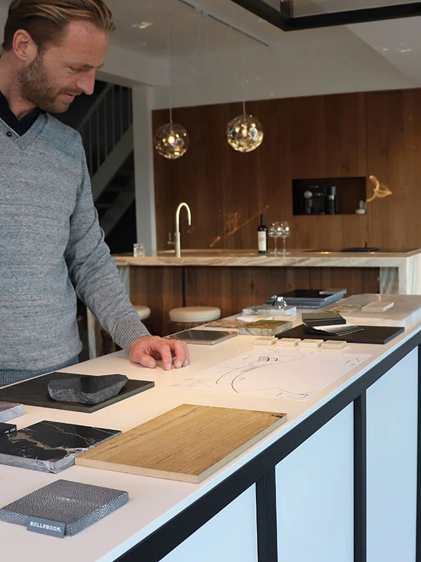 Bolleboom bekijkt materiaalstalen en een ontwerp in de studio