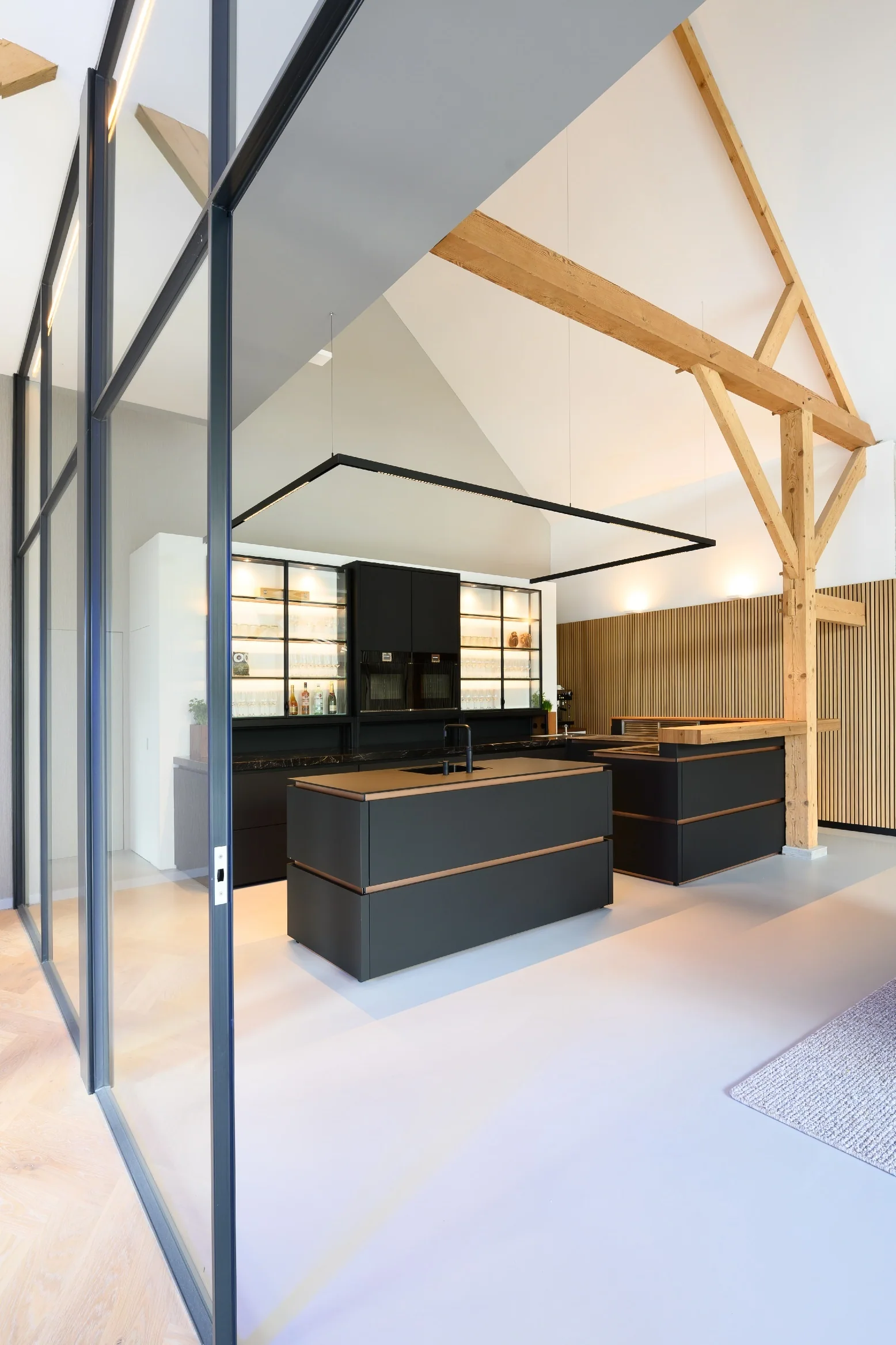Donkere keuken met eiland onder de hoge houten draagconstructie